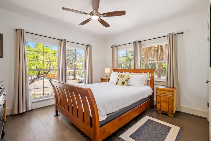 El segundo dormitorio de arriba cuenta con una cama tamaño queen y un ventilador de techo. 