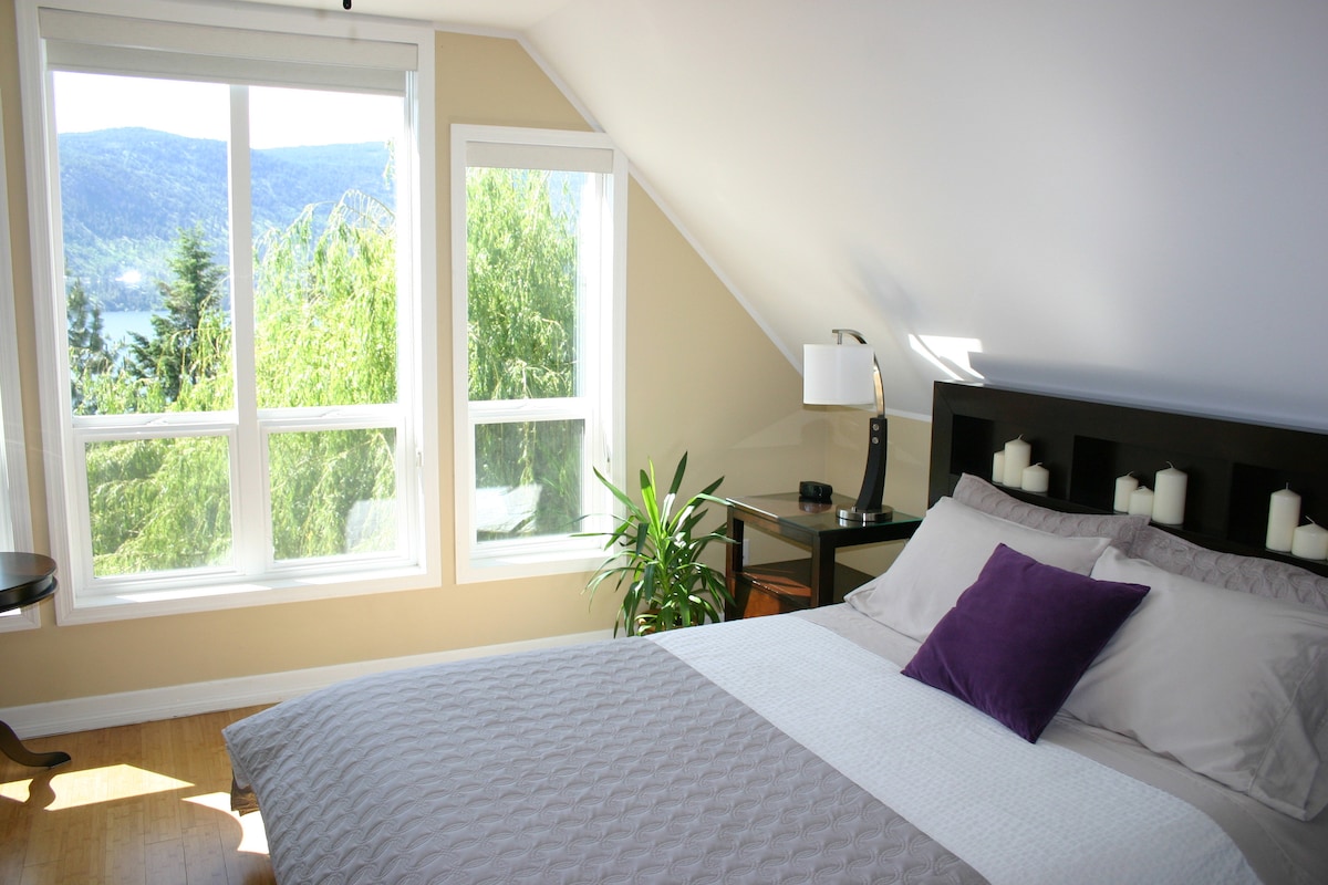 主卧配有标准双人床，可欣赏奥卡纳根湖和山脉的美景。