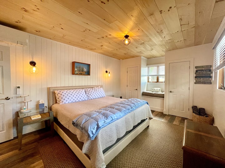 Голямо двойно легло с големи нощни шкафчета, кът за прозорци и двойни гардероби.