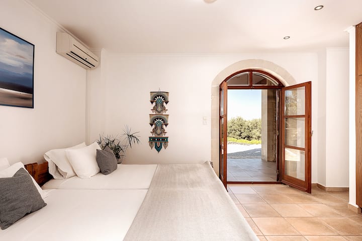 Spálňa 3 na dolnom poschodí s dvoma samostatnými posteľami a prístupom do vonkajšieho priestoru a bazéna, prejdite sprchou vpravo.