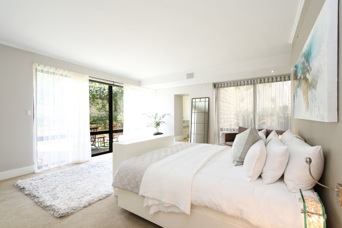 СПАЛЬНЯ 1: двуспальная кровать размера King size с собственной ванной комнатой.
Освещение и просторное дневное время с частным патио и видом на сад.