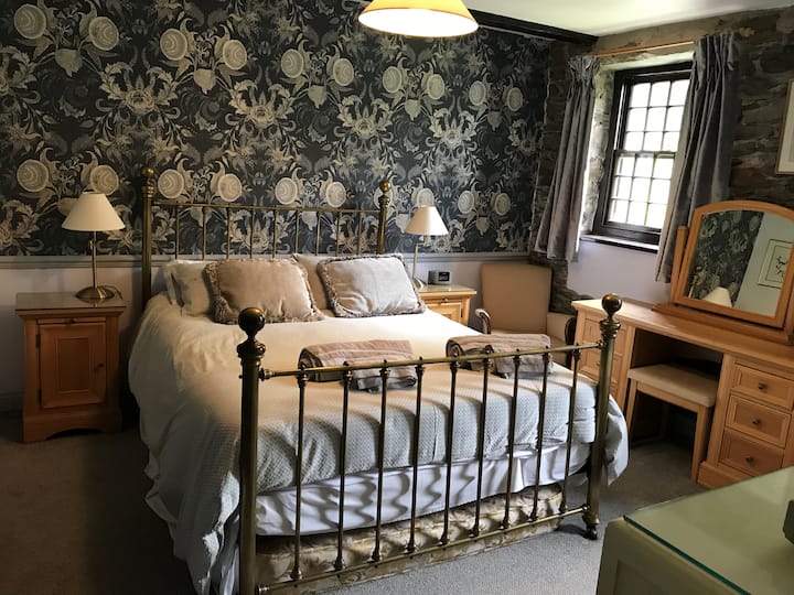 Posteľ King a toaletný stolík v hlavnej spálni. Tapeta Christian Lacroix na vylepšenie krásnych kamenných stien