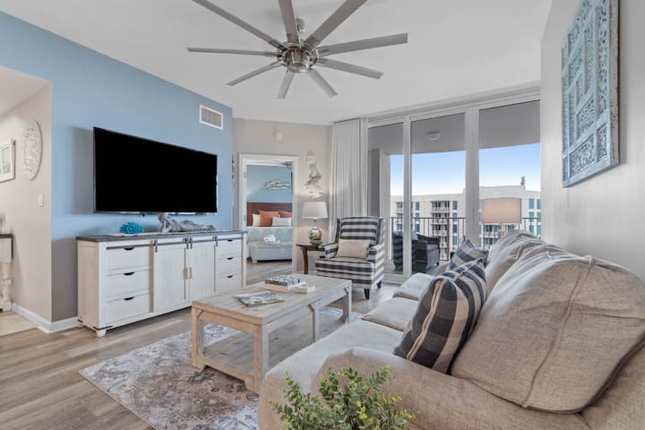 Living room w/ a Queen sofa sleeper, sliding doors out to your balcony with both Gulf and Lagoon Pool views, Large Flat screen TV for lounging after a day at the beach or pool. (Plaid Chair has been replaced w/another chair - New photos coming soon).
