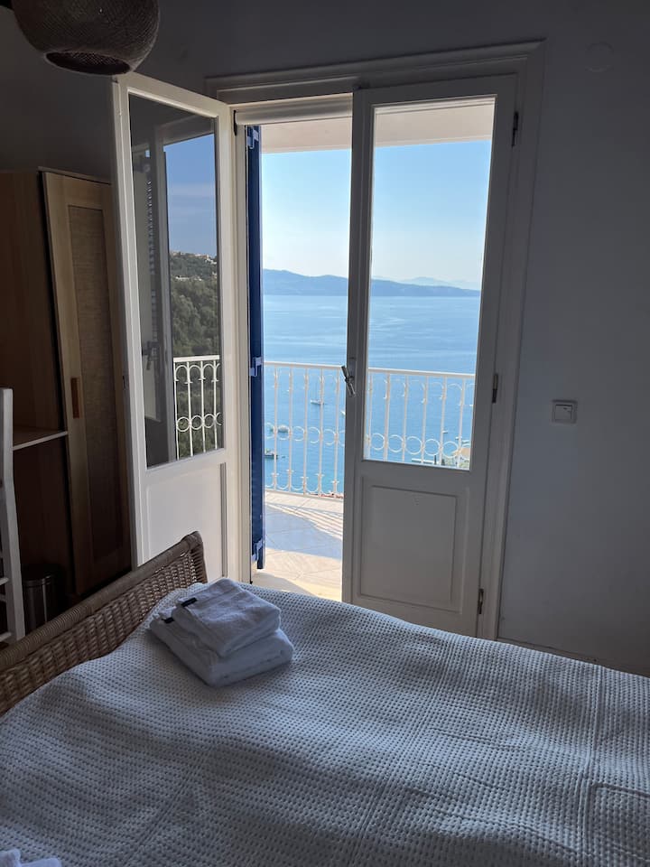Chambre avec lit double et portes menant au balcon. Climatisation ainsi que ventilateur de plafond dans la chambre.
La nuit, fermez les portes en bois devant les portes et il fera complètement sombre dans la chambre.