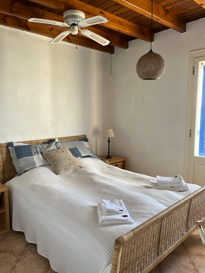 Chambre 2. Chambre avec lit double et portes menant au balcon. Climatisation ainsi que ventilateur de plafond dans la chambre. La nuit, fermez les portes en bois devant les portes et il fera complètement sombre dans la chambre.