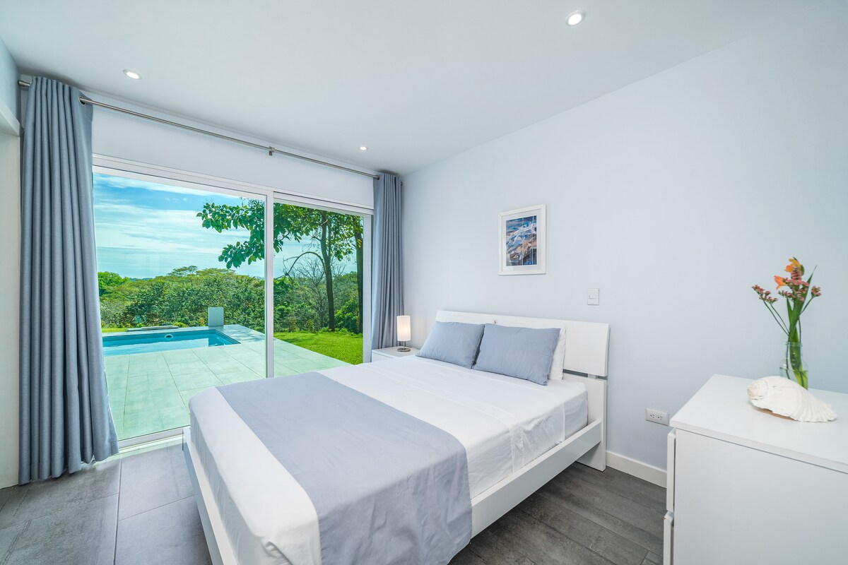 ดื่มด่ำกับการพักผ่อนในห้องนอนที่น่าทึ่งนี้ เตียงขนาดควีนไซส์เฟอร์นิเจอร์สีขาวและประตูกระจกสูงจากพื้นจรดเพดานที่เผยให้เห็นลานระเบียงส่วนตัวและสระว่ายน้ำแบบอินฟินิตี้สร้างสถานที่พักผ่อนที่หรูหราอย่างแท้จริง