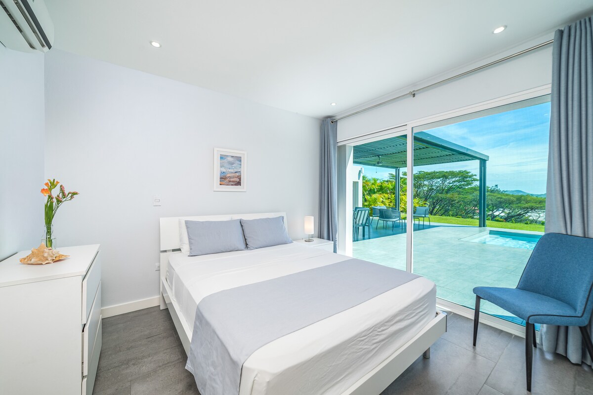 เพลิดเพลินกับการนอนหลับอย่างสงบในห้องนอนที่น่าทึ่งนี้ซึ่งมีเตียงควีนไซส์เฟอร์นิเจอร์สีขาวและประตูกระจกบานเลื่อนจากพื้นจรดเพดานที่เปิดออกสู่ลานระเบียงส่วนตัวและสระว่ายน้ำแบบอินฟินิตี้ วิวอันเงียบสงบและองค์ประกอบทางธรรมชาติสร้างโอเอซิสที่แท้จริง