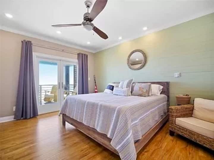 Chumba cha kulala cha msingi chenye mandhari nzuri ya ufukwe na maji. 