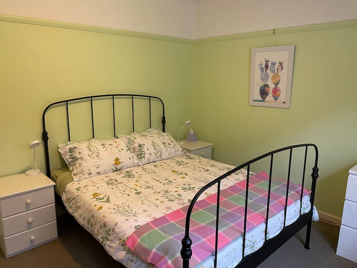 Chumba cha Kijani, kitanda cha malkia, sehemu ya kufanyia kazi ya dawati na mwonekano mzuri wa msitu.