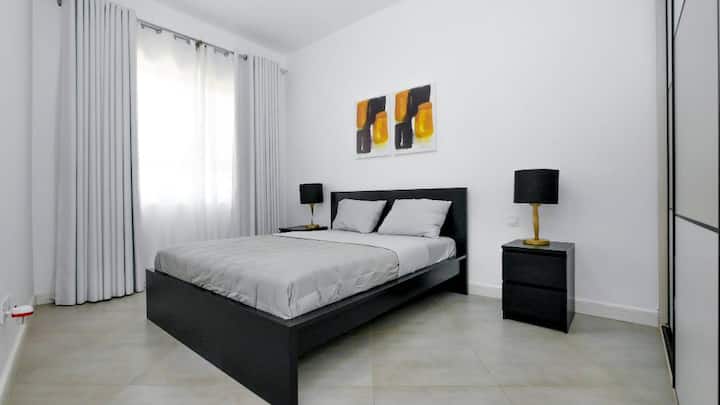 Druhá spálňa s vlastnou kúpeľňou so super pohodlným matracom veľkosti queen size a krásnym nástenným umením v príjemnej miestnosti naplnenej slnkom 