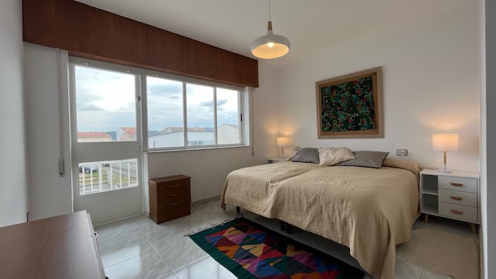 غرفة رئيسية تضم سريرين فرديين وشرفة صغيرة