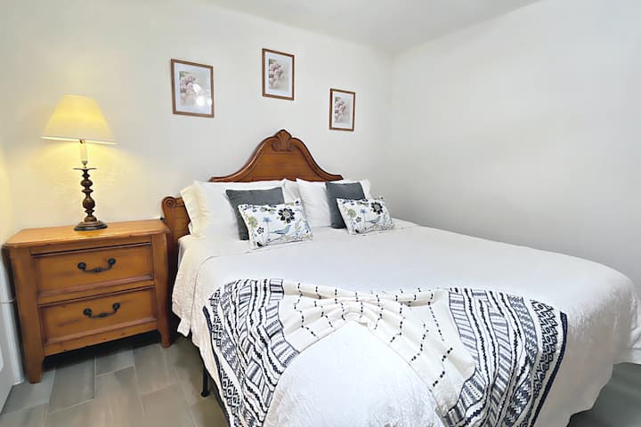 Cama king con mesita de noche y un lugar para cargar tu teléfono.