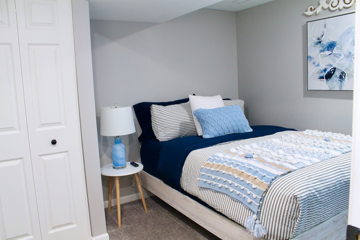 El dormitorio de nivel inferior ofrece un ambiente único con su ambiente distintivo. Está amueblado con una cómoda cama doble y cuenta con un elegante televisor de pantalla plana.