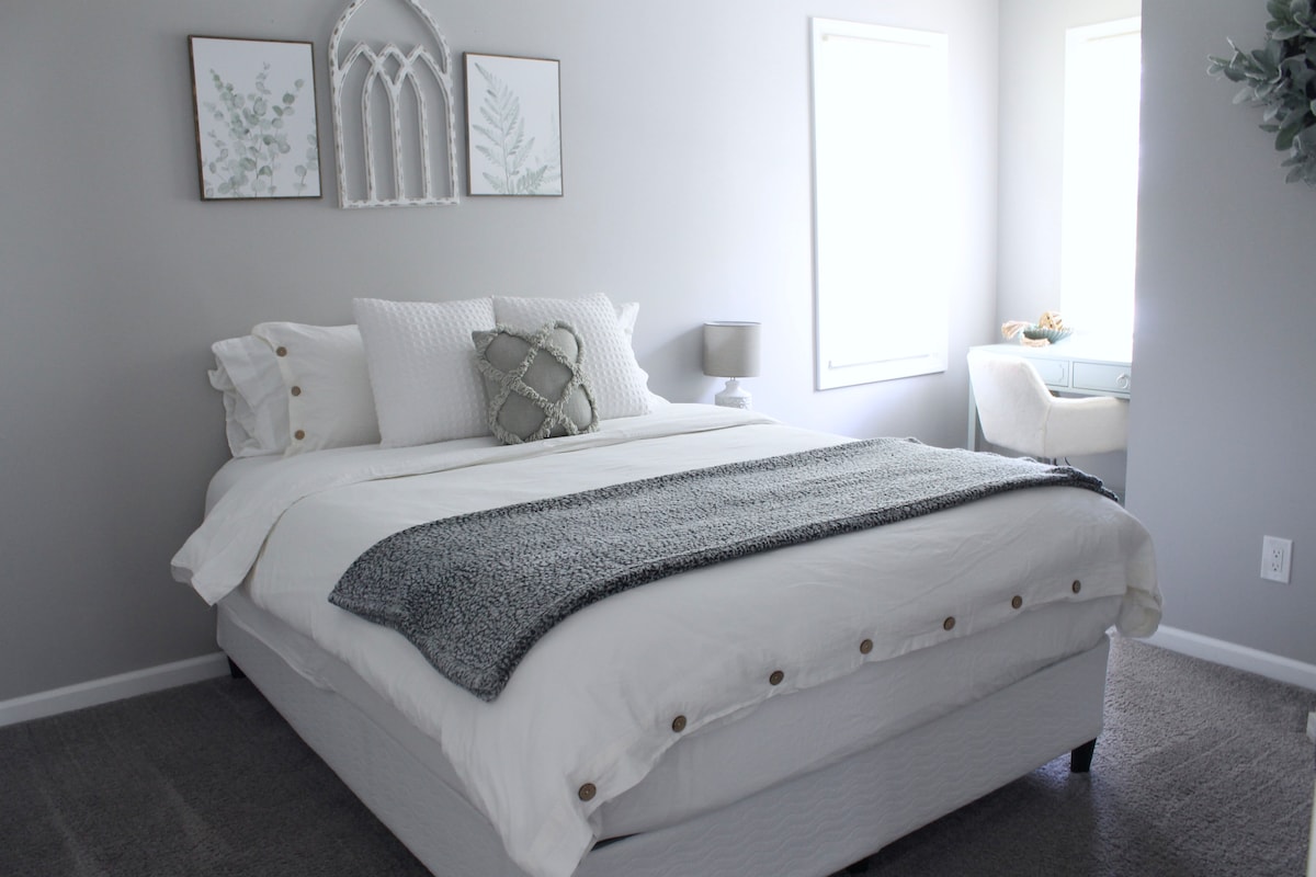 La cama queen en el dormitorio del nivel principal está acompañada de un cómodo escritorio, perfecto para los asistentes a las vacaciones que necesitan ponerse al día con el trabajo durante su estancia.