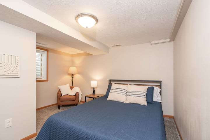 Lower level queen with 43" Roku TV, sitting area, walk-in closet, premium mattress, and dedicated workspace.