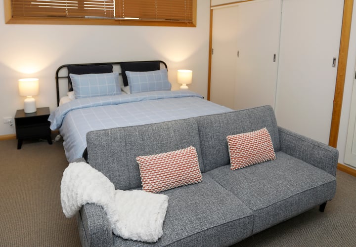 Dormitorio principal con cama tamaño king, sofá cama doble, televisión (Chromecast) y vistas a la playa.