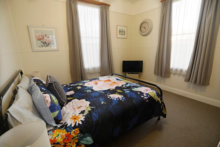 Segundo dormitorio con cama queen y televisor con cromecast