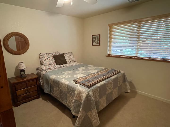 Cama tamaño queen con armario y bonita vista del bosque.