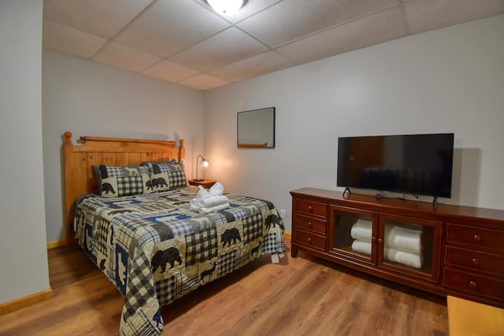 Chumba cha malkia cha kiwango cha chini kilicho na runinga janja. 