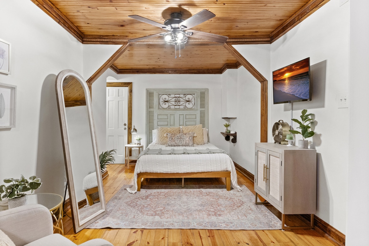 Private bedroom with queen size bed, dresser, full mirror and seating area. 