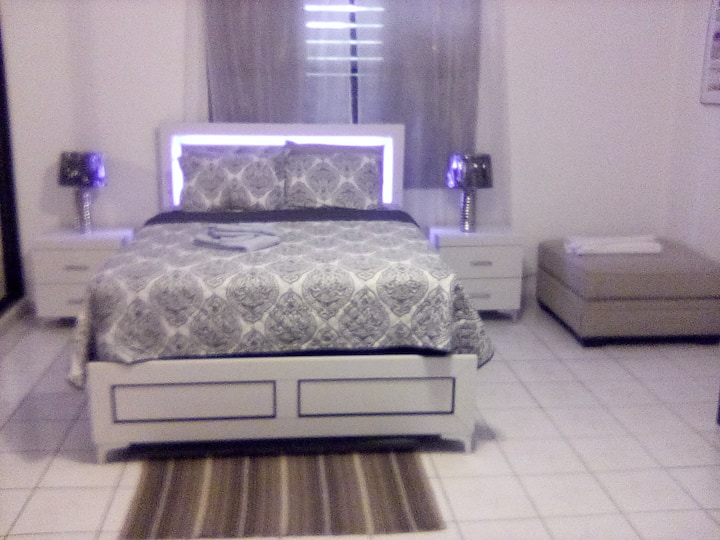 Hoofdslaapkamer: het hoofdeinde heeft drie lichtinstellingen, plafond- en voetstukventilatoren, uitzicht op gedeeltelijk landschap.