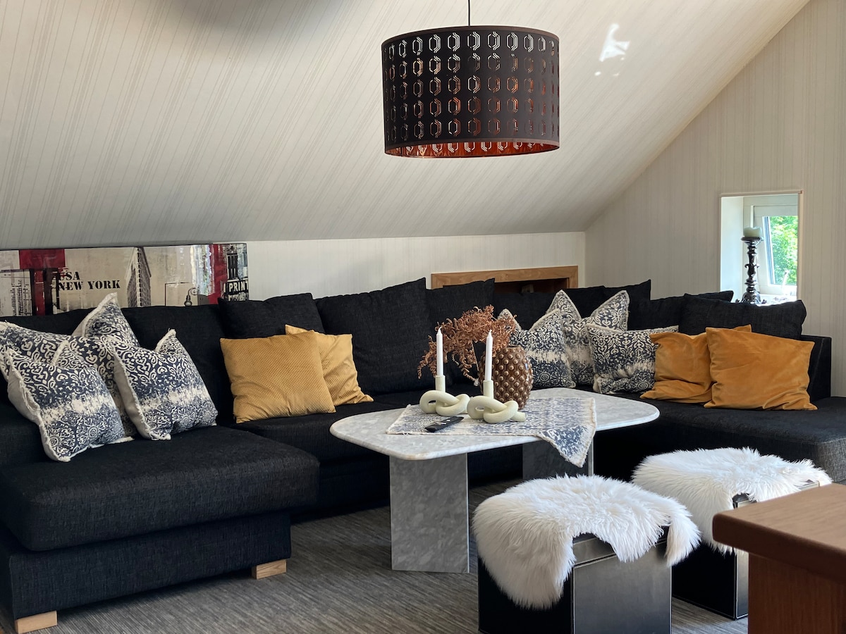 ห้องนั่งเล่นชั้นบนพร้อมโซฟาเข้ามุมทีวีและ XBox One X