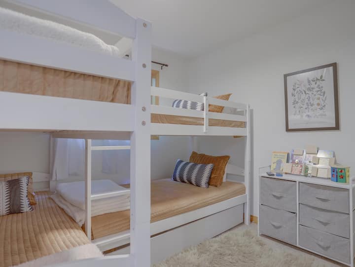 Chambre au premier étage avec deux ensembles de lits superposés et des jouets pour vos petits !