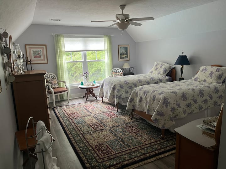 Spavaća soba s 2 odvojena kreveta i uredskim prostorom u ugradbenom ormaru.