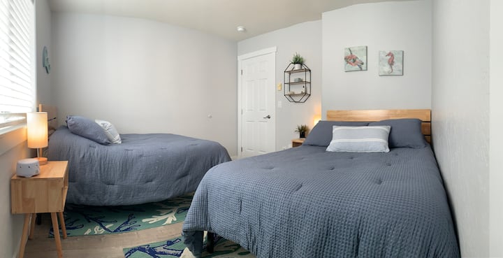 The second downstairs bedroom has two full size beds with memory foam mattresses and super comfy bedding! The small lamps on the nightstands come with USB outlets for charging your devices.