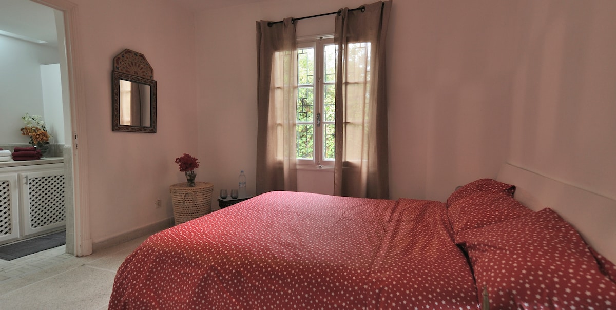 غرفة نوم حمراء مع حمام داخلي.