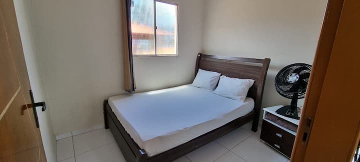 Habitación con una cama doble y ventilador.