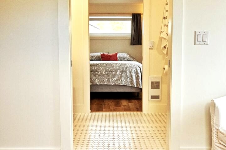 从双床卧室俯瞰两扇口袋门，穿过大型双人梳妆台共用浴室进入加大双人床卧室。 所有卧室都有长长的倾斜窗户，在床上和旁边转动窗户，以获得自然光和通风。 