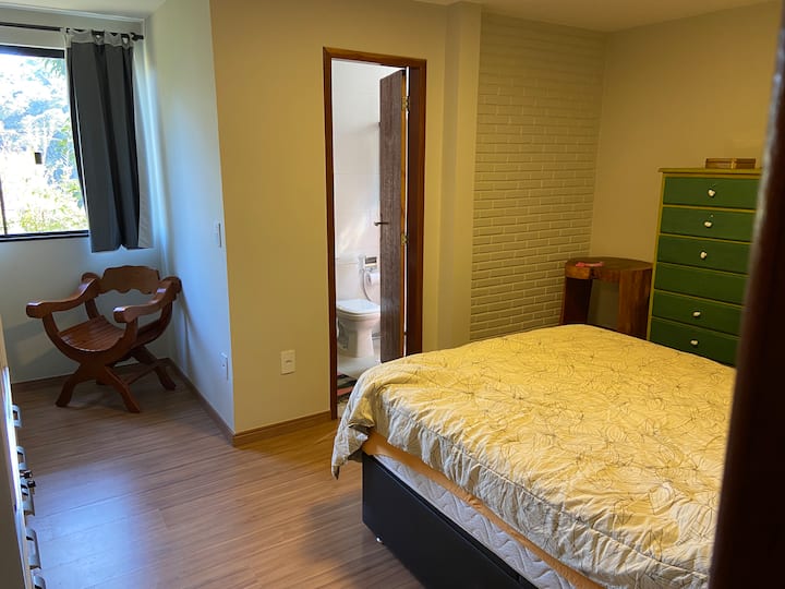 Dhomë gjumi me suitë në katin e poshtëm të shtëpisë.