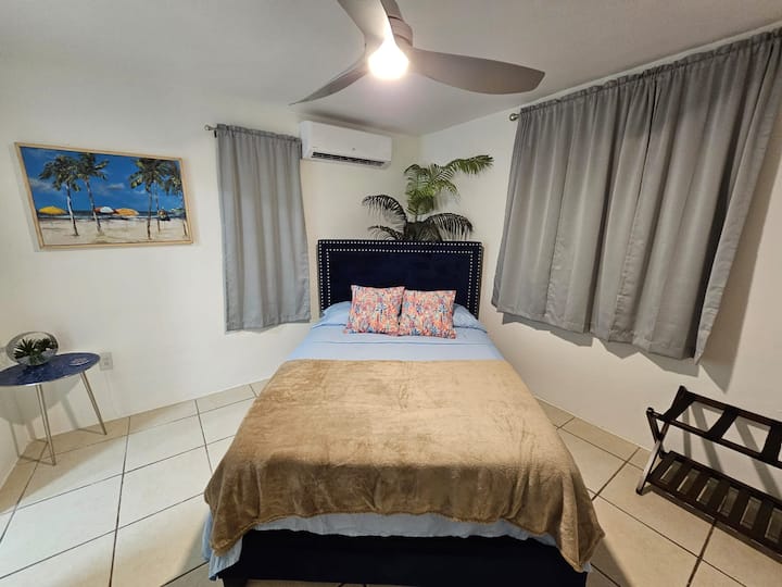 Chambre surdimensionnée avec climatisation, lit double, placard, porte-bagages, commode et salle de bain complète