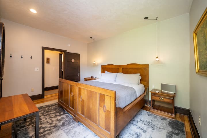 Dormitorio n.º 5 (segundo piso) con una cama tamaño king y un baño completo compartido con la habitación n.º 6. Se accede al baño a través de un pasillo corto que se comparte con la habitación n.º 6.