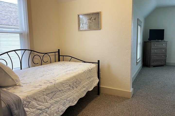 The upstairs king bedroom offers a twin daybed with lake views for additional sleeping space.