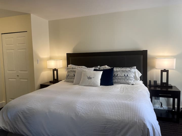 חדר שינה ראשי של יחידה עם חדר שינה אחד כולל מיטת קינג סייז נוחה עם מצעים יפים וטלוויזיה חכמה בגודל 40אינץ '.  יהירות בסוויטה עם מראת איפור קלה, צמוד ל -5 חלקים והגישה הפרטית שלכם למרפסת.