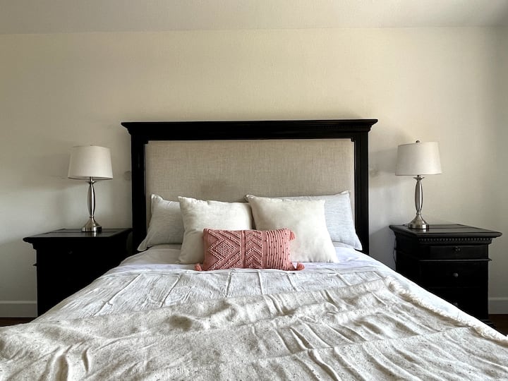 Dormitorio principal con cama tamaño king, baño privado y televisión