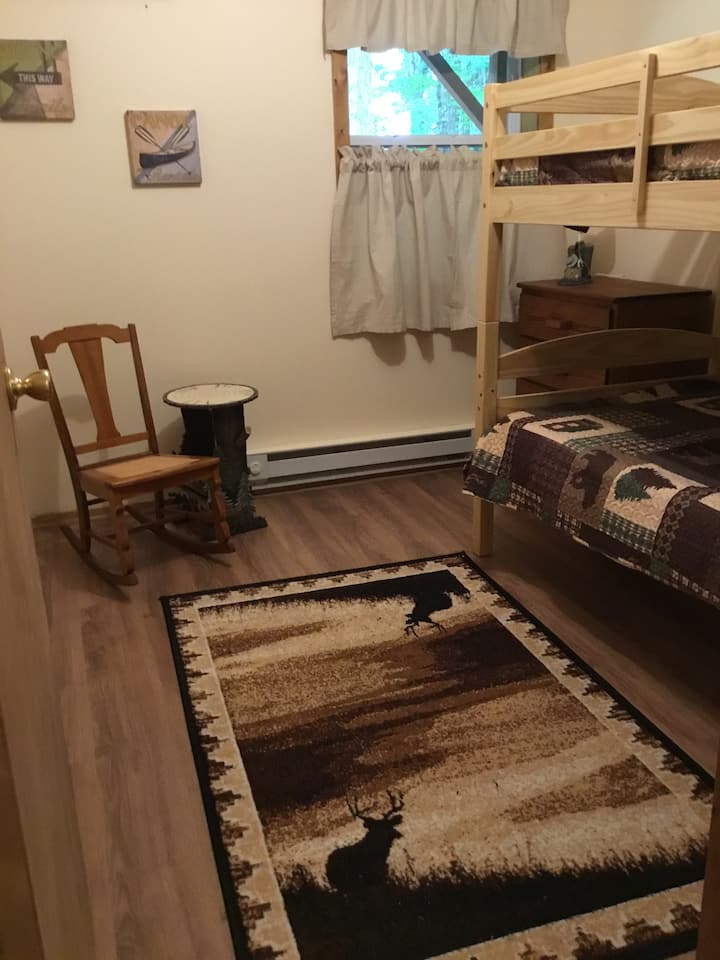 Chumba cha kulala cha kwanza upande wako wa kushoto kwenda chini ya barabara ya ukumbi kina vitanda vya ghorofa mbili na baraza la mawaziri lililojaa michezo na mafumbo