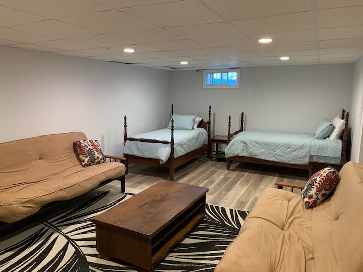 Chumba kikubwa cha kulala cha ghorofa ya chini chenye vitanda viwili viwili na futoni mbili ambazo zinafunguliwa hadi vitanda kamili. Kuna meza na viti pamoja na kabati katika sehemu hii