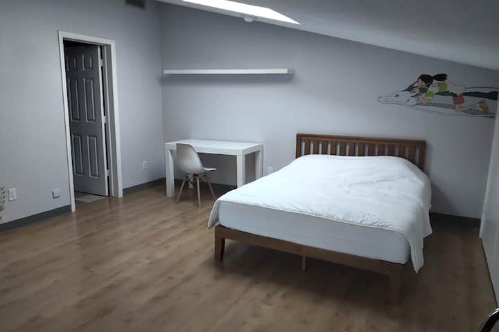 غرفة نوم كبيرة تضم حمامًا داخليًا وسريرين مزدوجين ، أحدهما به مرتبة مزدوجة قابلة للسحب