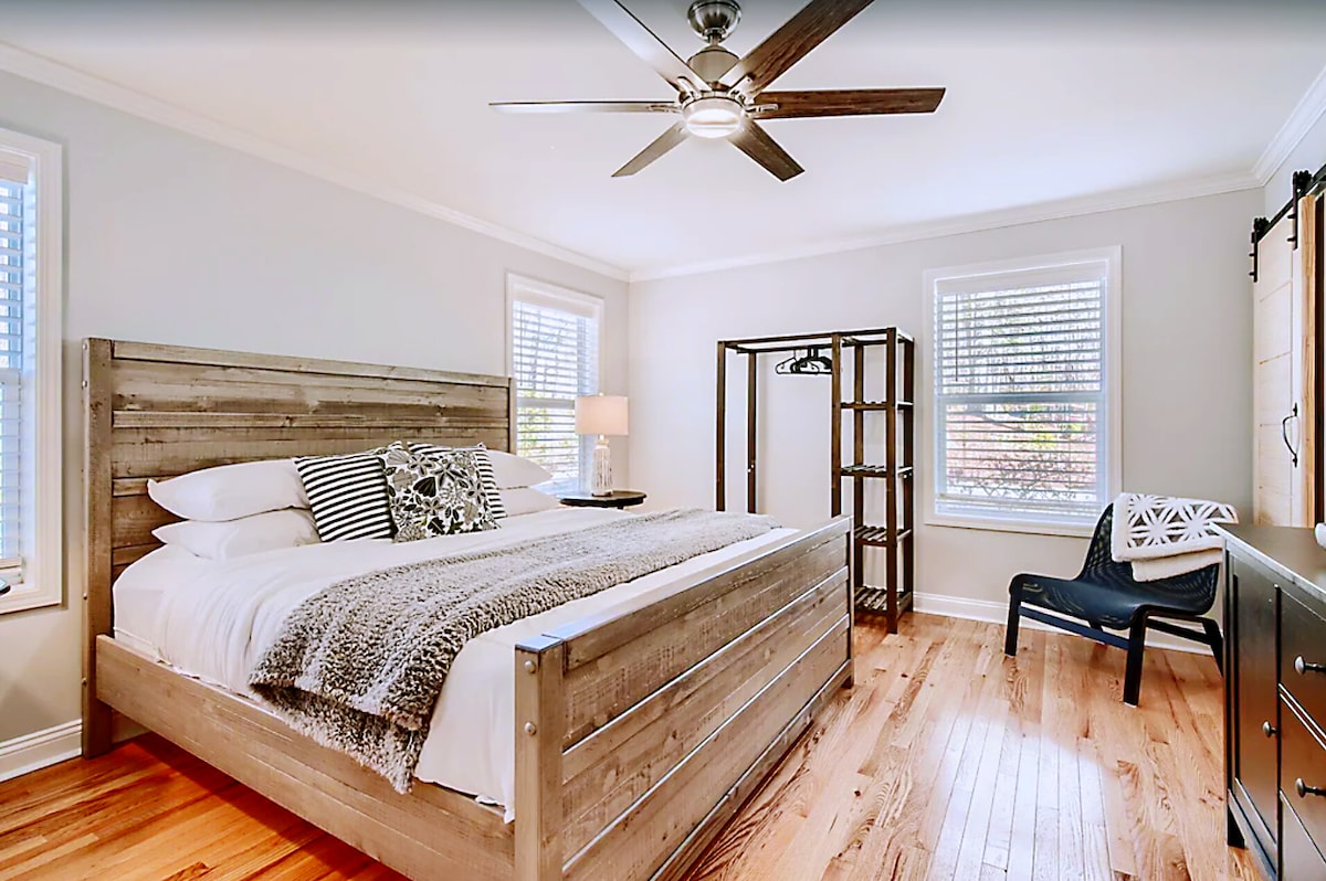 The main bedroom on the main floor with king-size bed, dresser, smart TV and private bathroom.