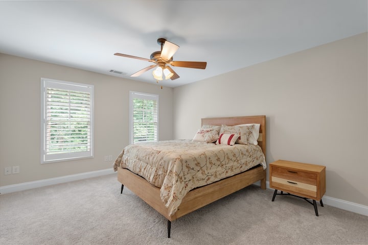 楼上1号卧室配有标准双人床、2个床头柜、吊扇和衣柜。