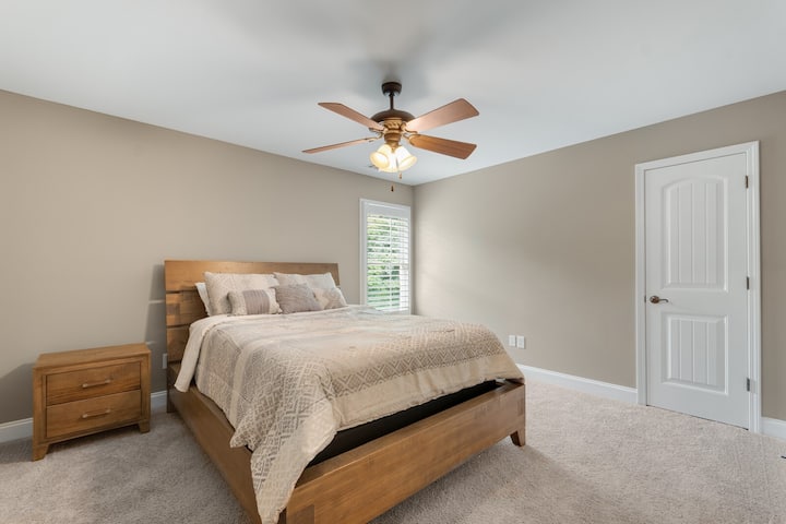 楼上2号卧室配有标准双人床、2个床头柜、吊扇和大型步入式衣柜。