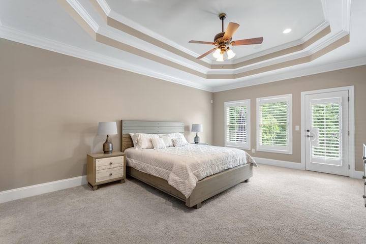 主卧位于主楼层，配备加大双人床、床头柜和大梳妆台。