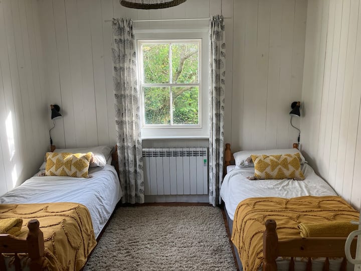 Двокреветна соба. Два удобни кревета, фиока, многу книги и мало биро и стол.