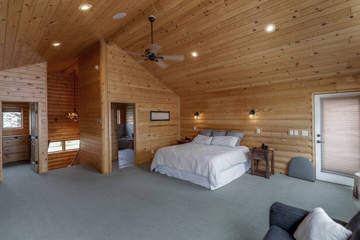 The master bedroom is a true spectacle: king bed, pull-out sofa, lavish private bath with jet tub and shower, fireplace, smart TV, and a private deck with a lake view.