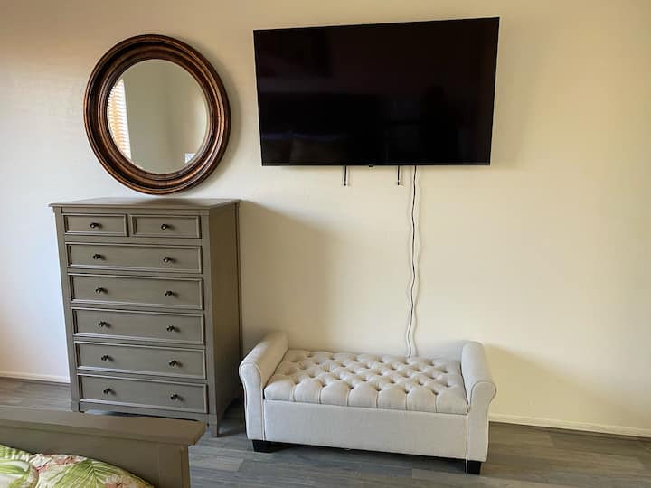 בחדר השינה הראשי יש טלוויזיית LG 4K LCD חדשה בגודל 55 אינץ' המותקנת על הקיר.