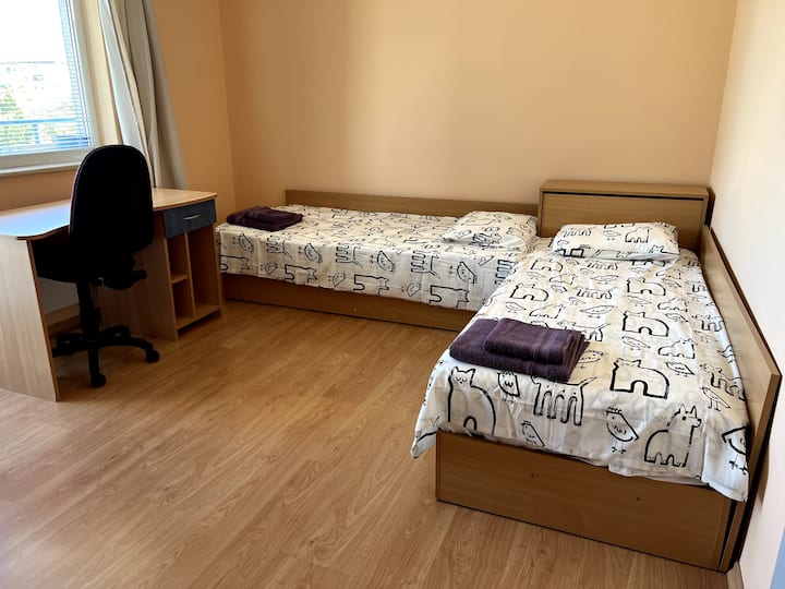 Second bedroom with two single beds an office desk and a wardrobe. Private balcony.