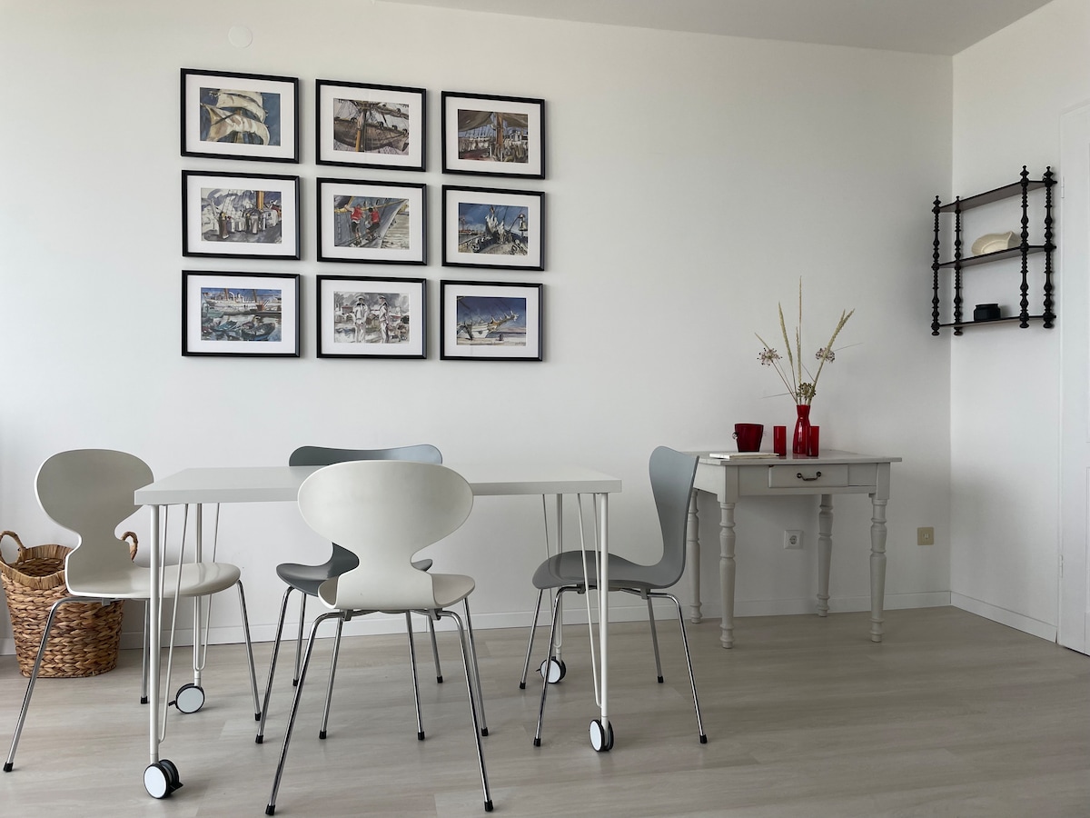 用餐区配有Arne Jacobsen椅子和Gorch-fock图片墙